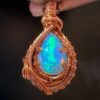 Ethiopian Witte Opaal pendant wrapped in intricate copper wire craftsmanship.