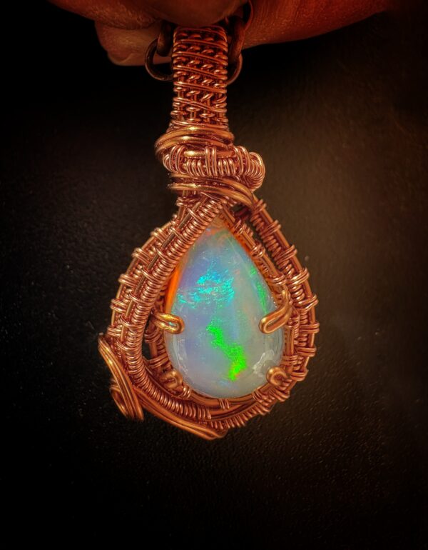 Witte opaal uit Ethiopië met koper draad omringd door metaalwerk.