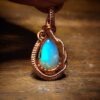 Opal pendant with copper wire wrapping, showcasing a vibrant blue and green play of colors.